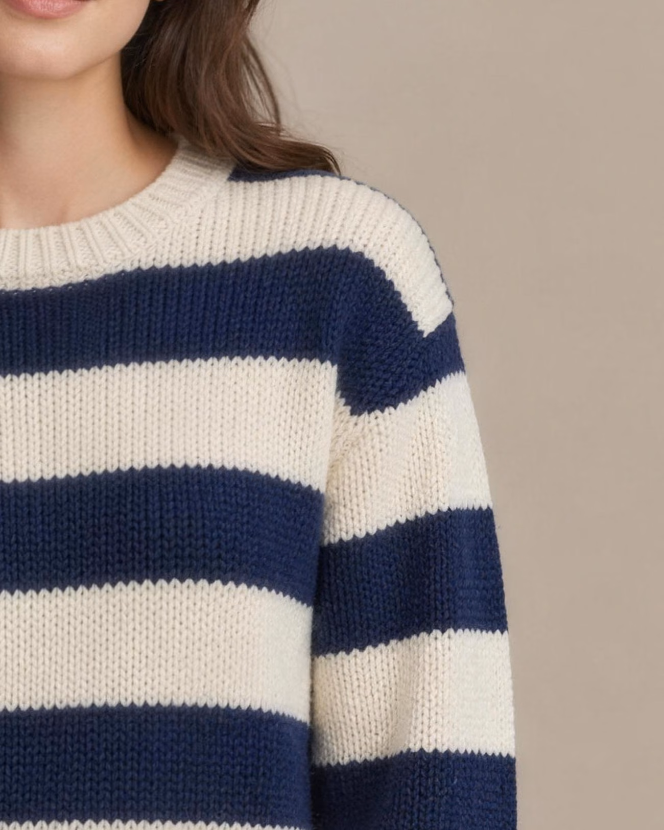 Close-up of the same image: Knit sweater with wide block stripes in navy and cream